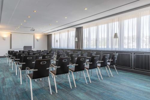a conference room with chairs and a podium at Radisson Blu Hotel Schwarzer Bock Wiesbaden in Wiesbaden