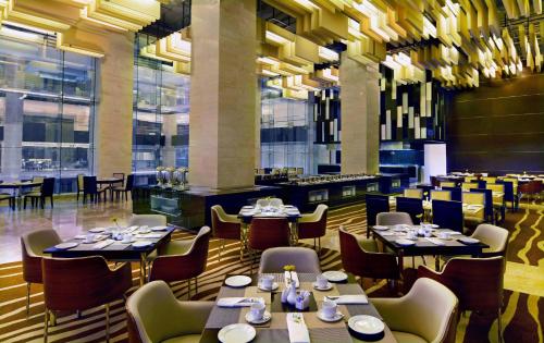 a restaurant with tables and chairs in a room at Radisson Blu Chattogram Bay View in Chittagong