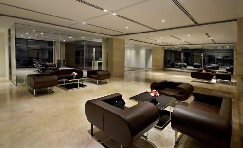 a lobby with leather chairs and tables and a salon at Radisson Blu Chattogram Bay View in Chittagong