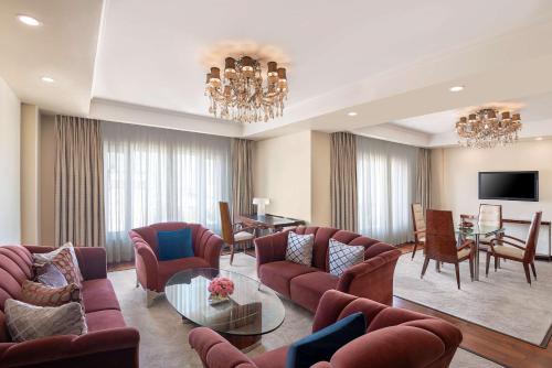a living room with couches and a dining room at Radisson Blu Hotel Ahmedabad in Ahmedabad