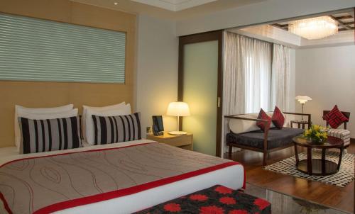 a bedroom with a large bed and a chair at Radisson Blu Hotel Ahmedabad in Ahmedabad