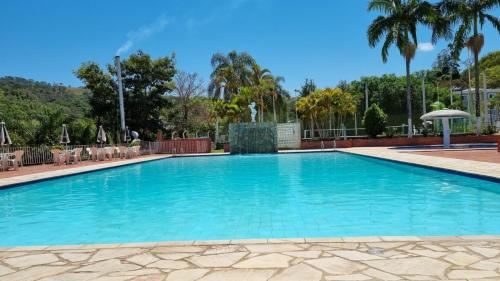 a large swimming pool with blue water at Hotel Cavalinho Branco Flat Service 615 in Águas de Lindóia