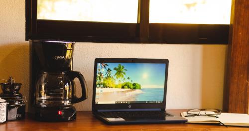 a laptop computer sitting on a desk next to a coffee maker at Rancho Los Barriles in Acaxochitlán