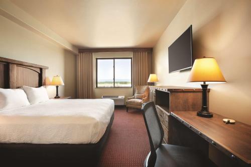 a hotel room with a bed and a television at Glacier International Lodge in Kalispell