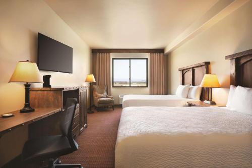 a hotel room with two beds and a television at Glacier International Lodge in Kalispell