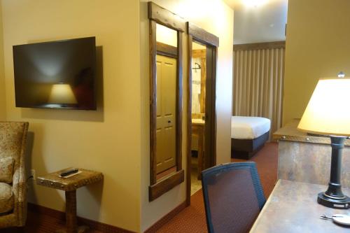 a hotel room with a mirror and a desk with a lamp at Glacier International Lodge in Kalispell