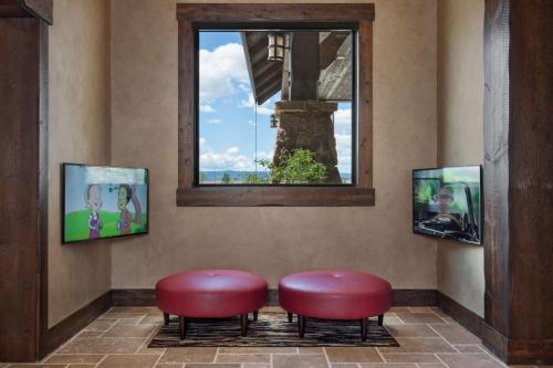 two red stools in a waiting room with a window at Glacier International Lodge in Kalispell