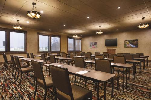 a conference room with tables and chairs and a screen at Glacier International Lodge in Kalispell