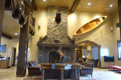 a lobby with a stone fireplace with a statue on a table at Glacier International Lodge in Kalispell