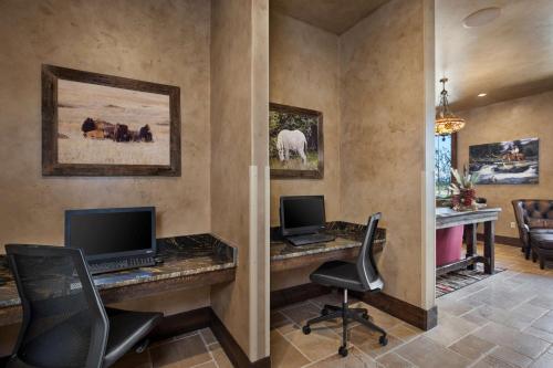 a home office with a desk with two computers at Glacier International Lodge in Kalispell