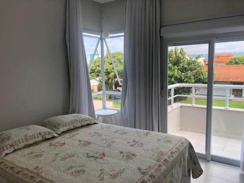 a bedroom with a bed in front of a window at Residencial Marilis in Palhoça
