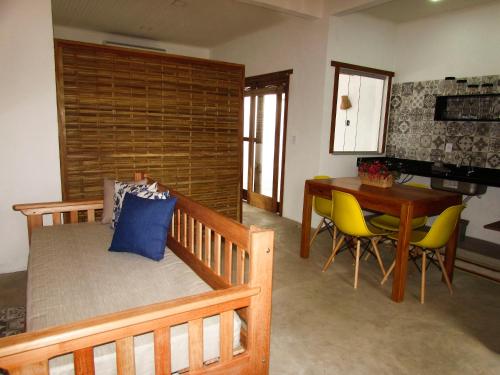 Aldeia Corumbau في كورومباو: غرفة نوم بسرير وطاولة وكراسي