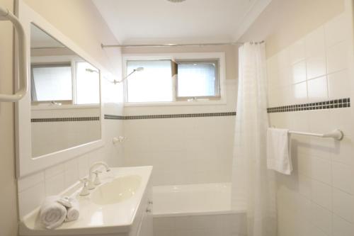 a white bathroom with a sink and a shower at Alloway in Eden