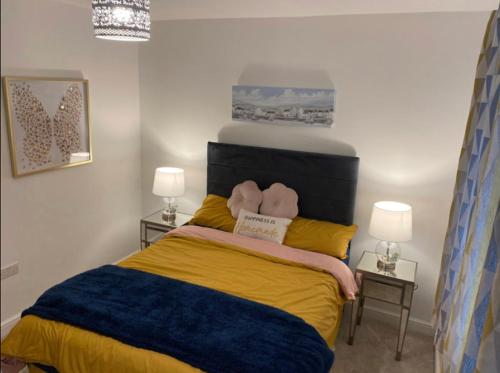 a bedroom with a bed with yellow and blue at Luxury Modern 1Bed Sea View Apartment in Llandrillo-yn-Rhôs