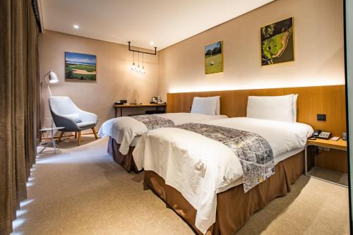 a hotel room with two beds and a chair at Mega Hotel in Chiayi City