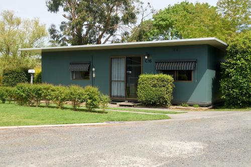 
a large green building with a tree in front of it at Pine Country Caravan Park in Mount Gambier
