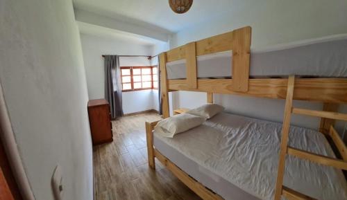 a bedroom with two bunk beds and a window at Casa La Parcela en Cieneguilla in Cieneguilla