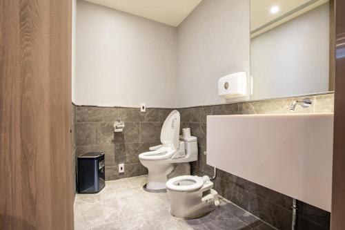 a bathroom with two toilets and a mirror at Mega Hotel in Chiayi City