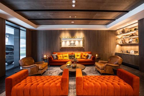 a living room with orange couches and a table and chairs at Mega Hotel in Chiayi City