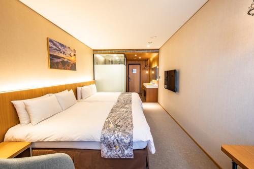 a hotel room with a bed and a desk at Mega Hotel in Chiayi City