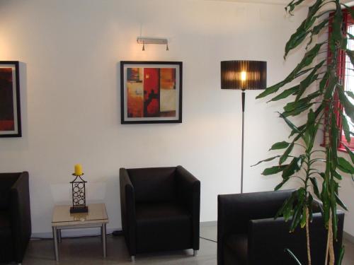 a living room with two chairs and a lamp at Hotel Botanico de Coimbra in Coimbra