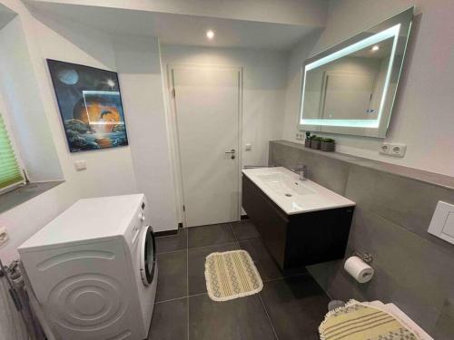 a bathroom with a toilet and a sink and a mirror at Eine charmante Wohnung wartet auf Sie in Alzenau in Unterfranken