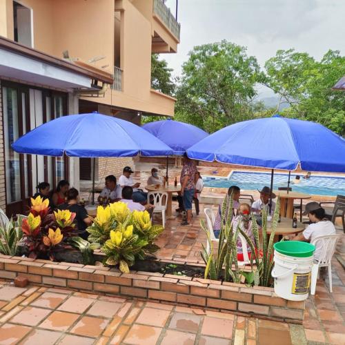 a group of people sitting at tables under blue umbrellas at BONANZA in Monterrey