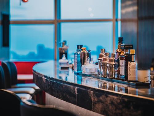 a bar with bottles of alcohol on a counter at Radisson RED Hotel Zhuhai Gongbei Port in Zhuhai