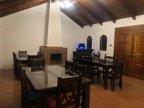 a dining room with tables and chairs and a fireplace at Hotel Mansion Del Rey in Antigua Guatemala