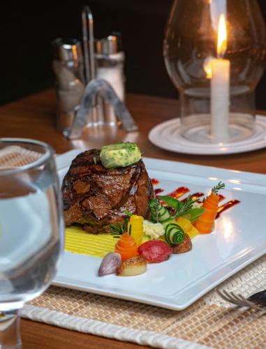 a plate with a steak and vegetables on a table at Idda Boutique Villa - Four Bedroom Luxury Villa with Private Pool Near the Beach in Ahangama