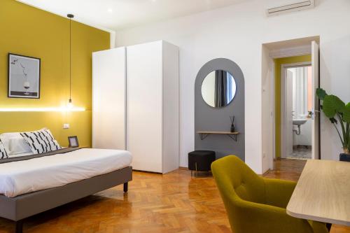 - une chambre avec un lit, une chaise et un miroir dans l'établissement Elegante appartamento vicino alla stazione - Gold, à Trieste