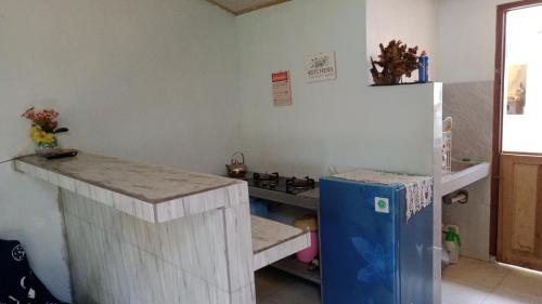 a kitchen with a counter and a refrigerator in a room at Belitung Backpacker in Tanjungpandan