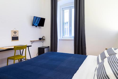 1 dormitorio con cama, escritorio y ventana en Pregiata camera con bagno privato - Blu di Persia, en Trieste