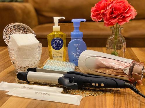 a hair dryer on a table with bottles of alcohol at TABISAI HOTEL House 博多 in Fukuoka