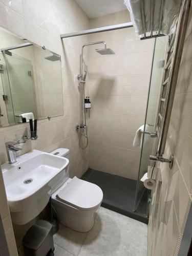 a bathroom with a toilet and a sink and a shower at City Centre Hotel in Tashkent