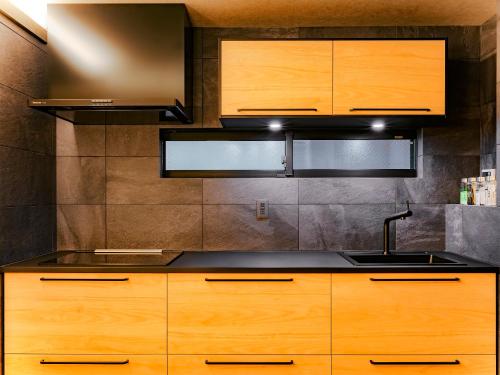 a kitchen with wooden cabinets and a sink at SAMURAI HOUSE Ⅲ in Nagoya