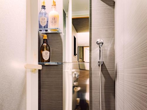 a bathroom with bottles on the door of a shower at SAMURAI HOUSE Ⅲ in Nagoya