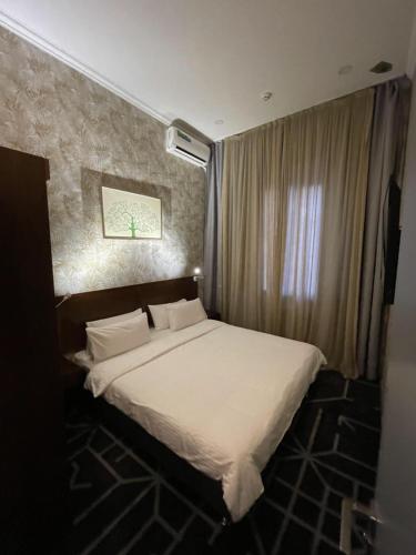 a bedroom with a large bed with white sheets at City Centre Hotel in Tashkent
