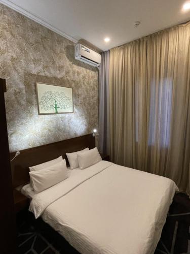 a bedroom with a large bed with white sheets at City Centre Hotel in Tashkent