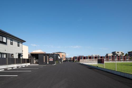 an empty road in a city with a fence at HOTEL R9 The Yard Asahishiro in Asahi