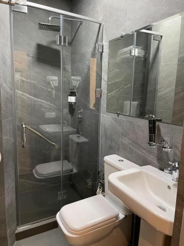 a bathroom with a shower and a toilet and a sink at City Centre Hotel in Tashkent