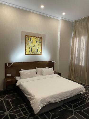 a bedroom with a large bed with white sheets at City Centre Hotel in Tashkent