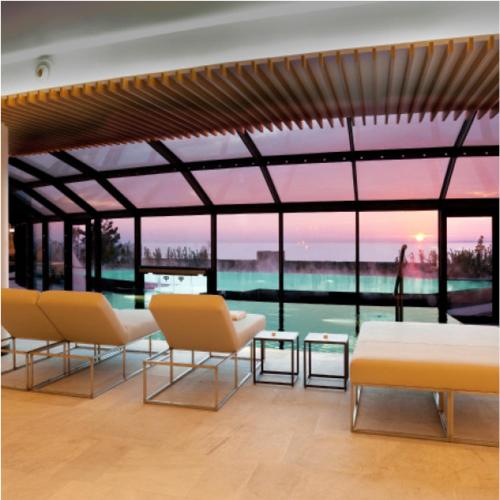 a room with two chairs and a table and windows at PORTOPICCOLO Luxury Penthouse Beach Included in Sistiana