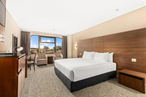 um quarto de hotel com uma cama e uma mesa em The Sydney Boulevard Hotel em Sydney