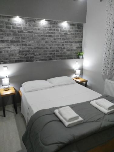a bedroom with a large bed with two towels on it at VIRGIN ROCKS APARTMENTS 1 in Kalabaka