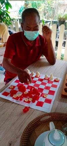 a man in a mask playing a checkerboard game at Daddy's homestay in Ban Bang Krasan