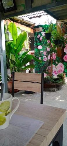 a wooden bench sitting next to a table with flowers at Daddy's homestay in Ban Bang Krasan