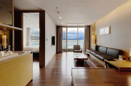 a hotel room with a couch and a bed at Sono Calm Yeosu in Yeosu