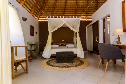 - une chambre avec un lit, une table et une chaise dans l'établissement Auberge de la Table, à Toliara