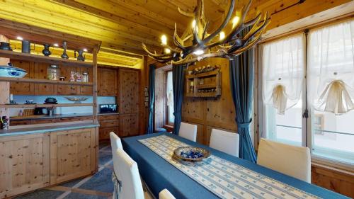 Un comedor con una mesa y una lámpara de araña. en Chesa Pidermann 5, en Pontresina